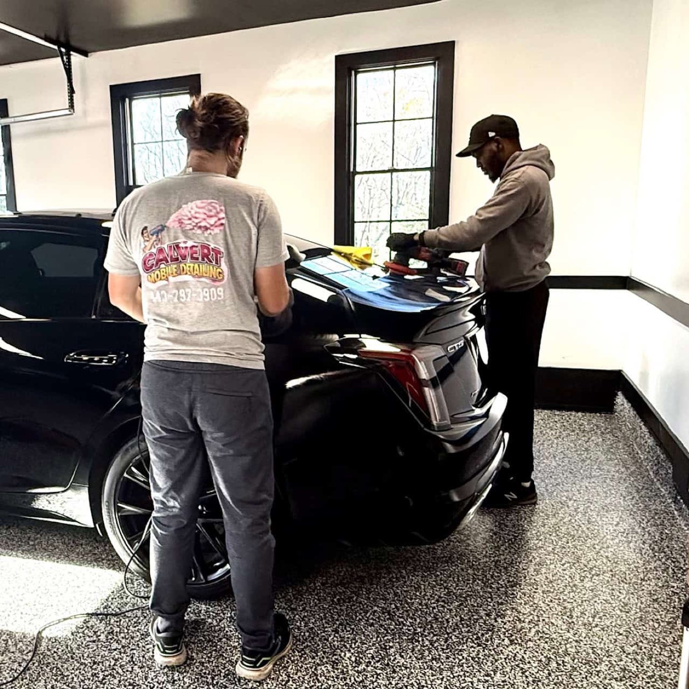 Calvert Mobile techs polishing a black Cadillac